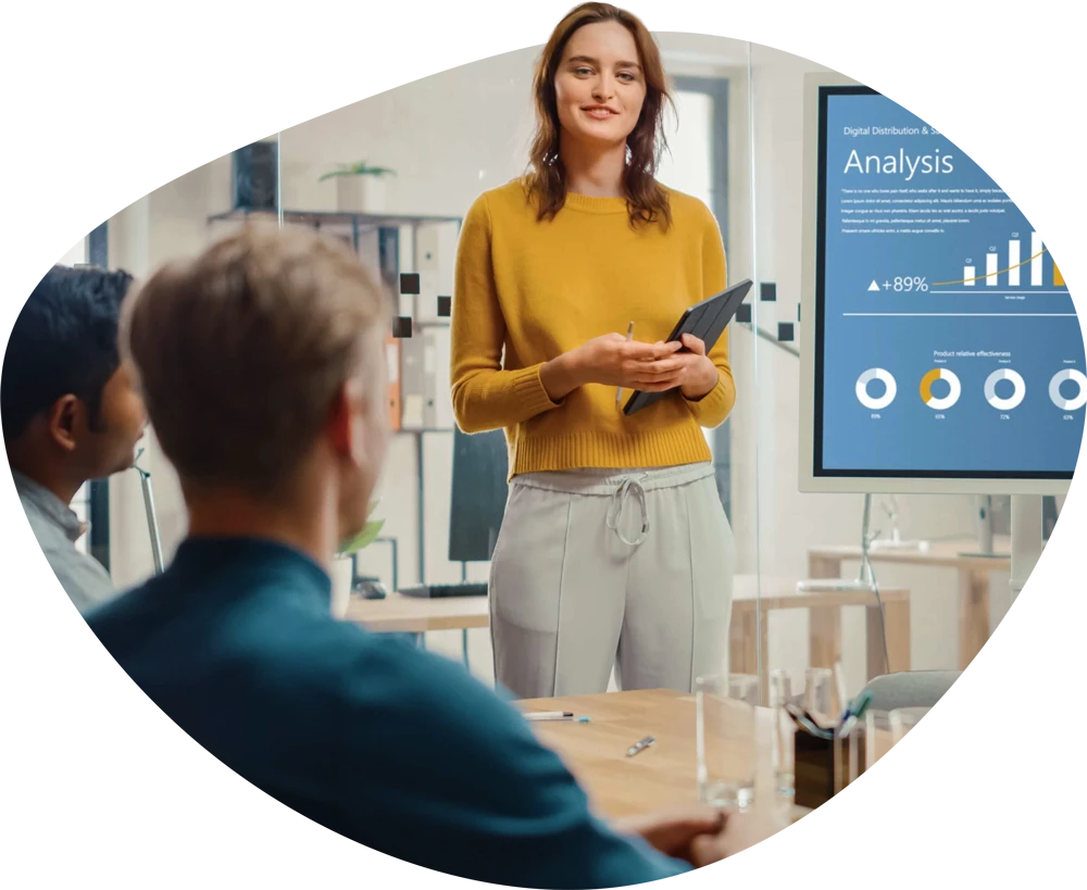 Woman standing in front a tv doing a presentation.